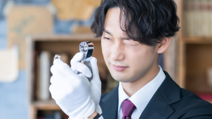 腕時計を丁寧に査定する査定員